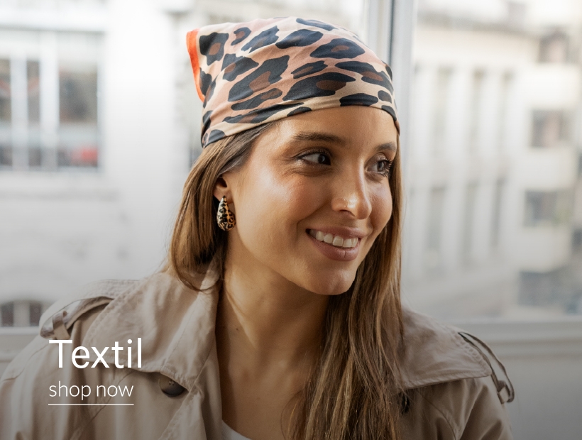 Mujer sonriendo con kimono y aros y collar con forma de corazon. Con inscripción "Textil. Shop Now"